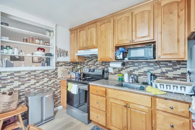 a kitchen with stainless steel appliances granite countertop a sink a stove and cabinets