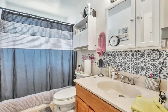 a bathroom with a sink a toilet and shower curtain