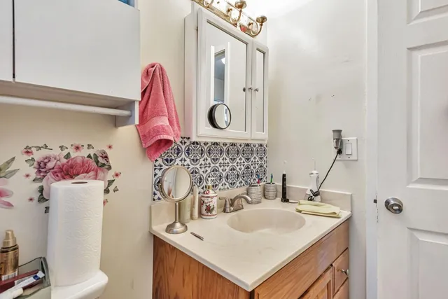 a bathroom with a sink vanity mirror and toilet