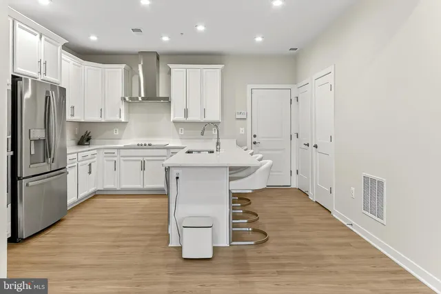 a kitchen with kitchen island granite countertop a sink cabinets and stainless steel appliances