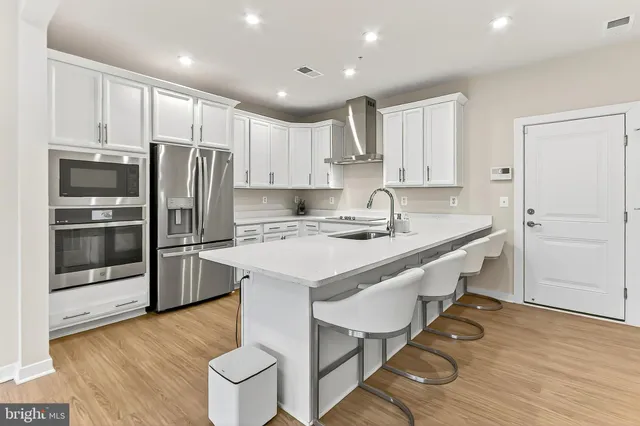 a kitchen with kitchen island granite countertop a sink a stove and refrigerator