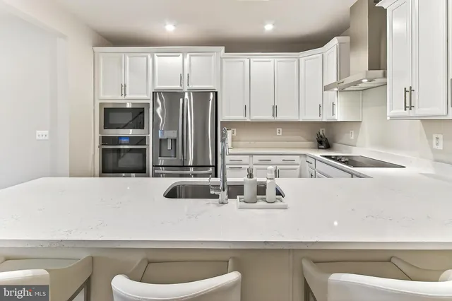 a kitchen with kitchen island a sink stove and refrigerator