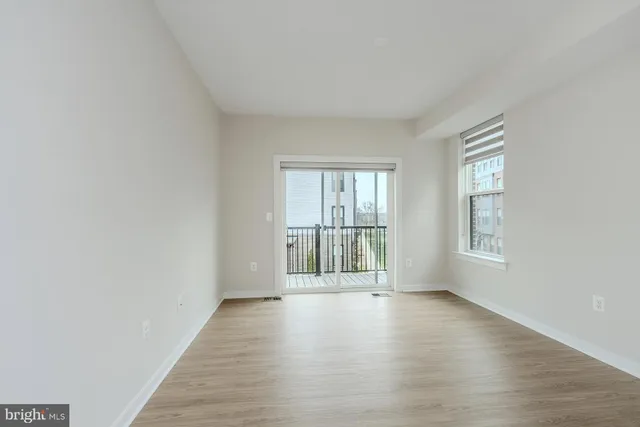 a spacious bedroom with a bed a dresser and large window