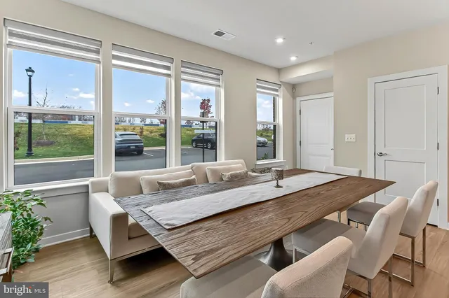 a dining room with furniture a window and a flat screen tv