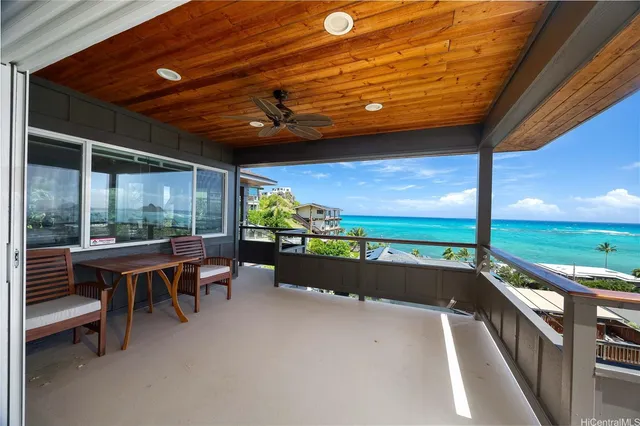 a view of a patio with table and chairs and wooden fence