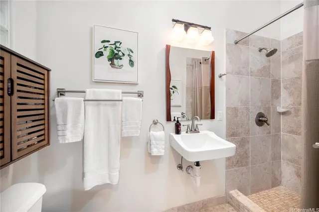 a bathroom with a sink a toilet and shower