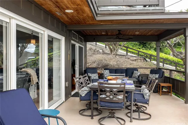 a patio with a table and chairs with a barbeque grill and a floor to ceiling window