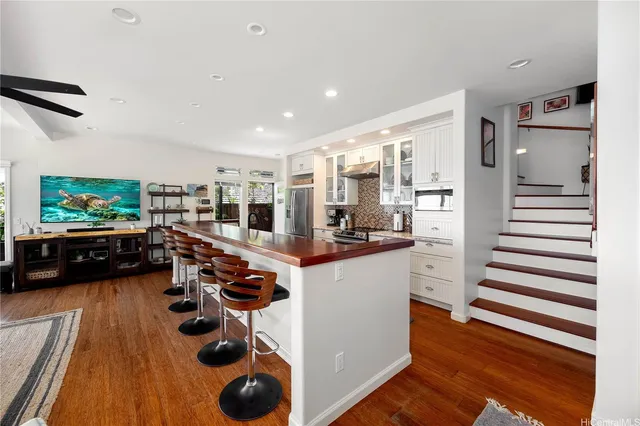 a kitchen with stainless steel appliances and wooden floor