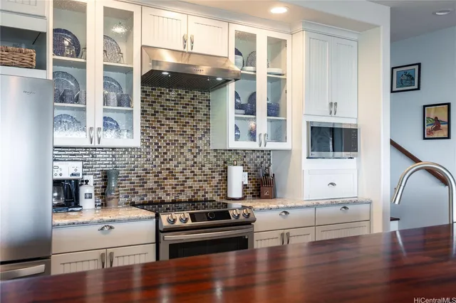 a kitchen with a refrigerator and a stove top oven