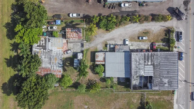 an aerial view of a house with outdoor space and a lake view in back