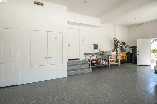 a view of a swimming pool with lawn chairs and large trees