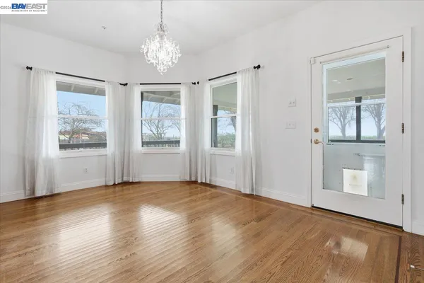 a dining room with furniture a chandelier and wooden floor
