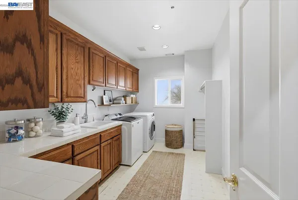 a view of a swimming pool with lawn chairs and large trees