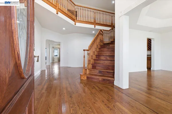 a view of a hallway with wooden floor and staircase