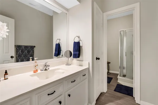 a en suite bathroom with a granite countertop sink and a mirror