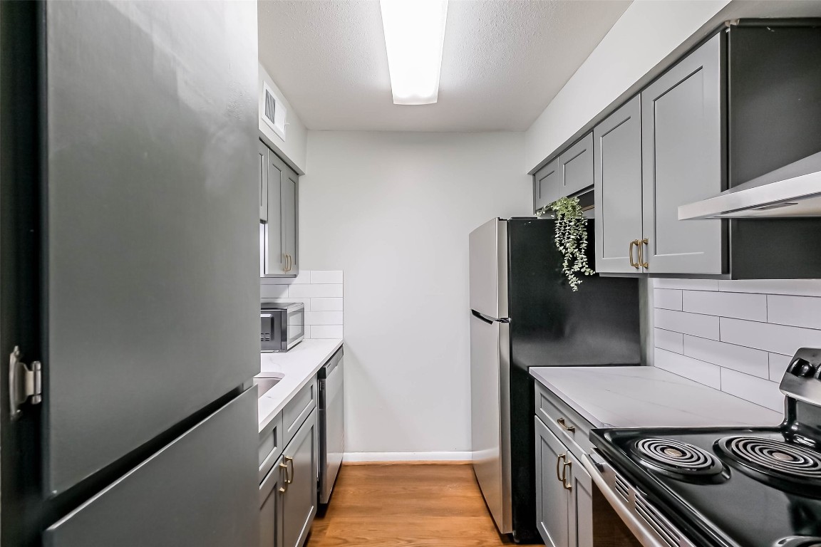 7575 Katy Freeway, Unit 101 Houston, TX 77024 - Photo 7 of 21 a kitchen with a stove and a refrigerator