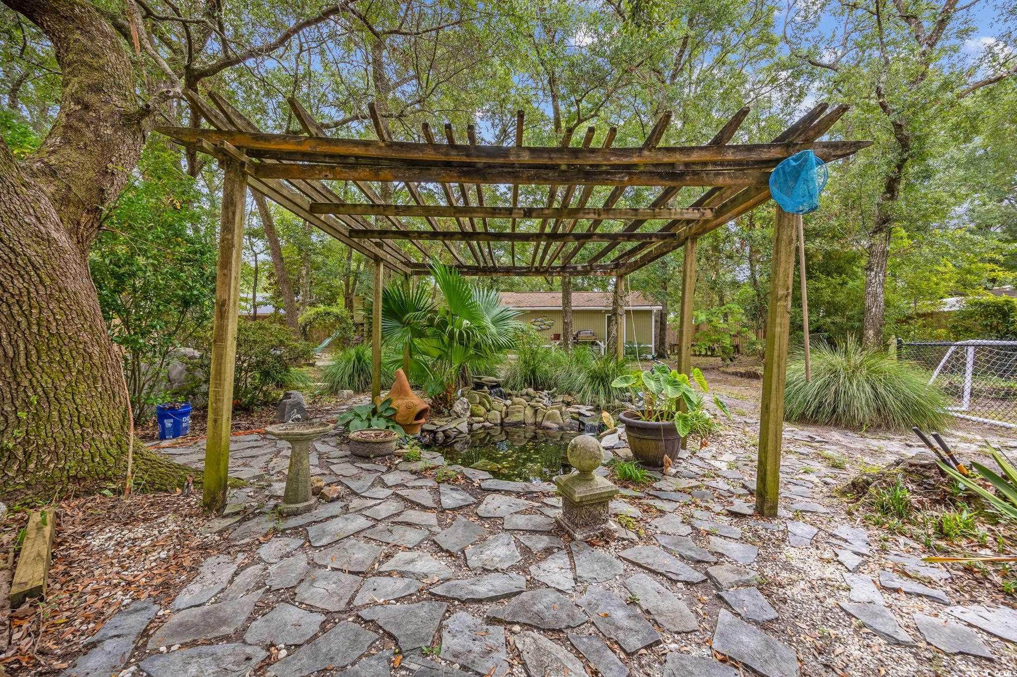 4303 Old Kings Highway Murrells Inlet, SC 29576 - Photo 25 of 34 View of yard with a pergola, a garden pond, and a patio
