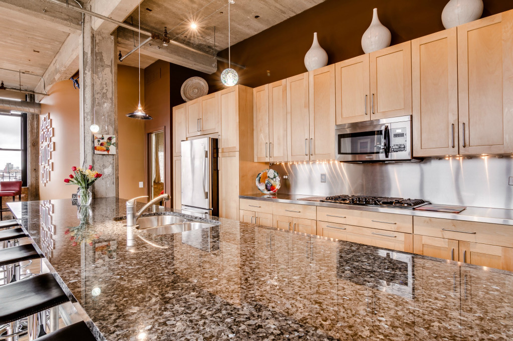 850 West Adams Street, Unit 6D Chicago, IL 60607 - Photo 9 of 35 a kitchen with stainless steel appliances kitchen island granite countertop a stove a sink and a microwave