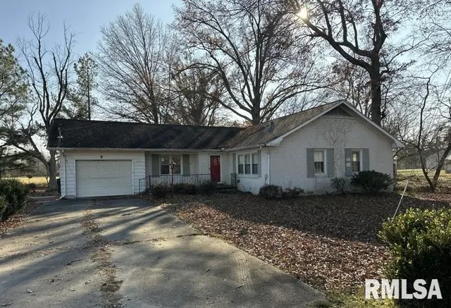 a front view of house with yard and trees in the background
