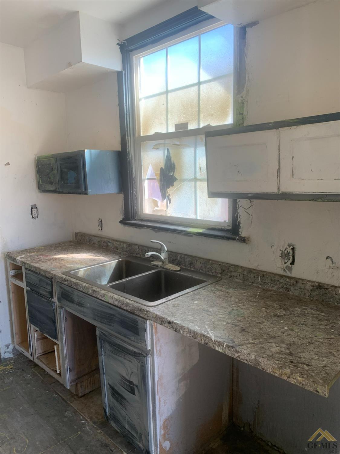Undisclosed Address Bakersfield, CA 93308 - Photo 3 of 10 a kitchen with a sink a counter top space and cabinets