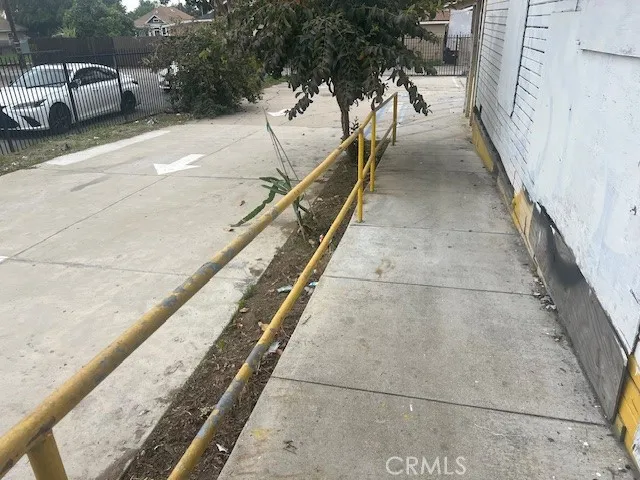a balcony with view of car parked on street side