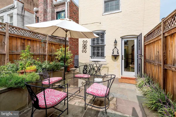 a patio with a table and chairs under an umbrella