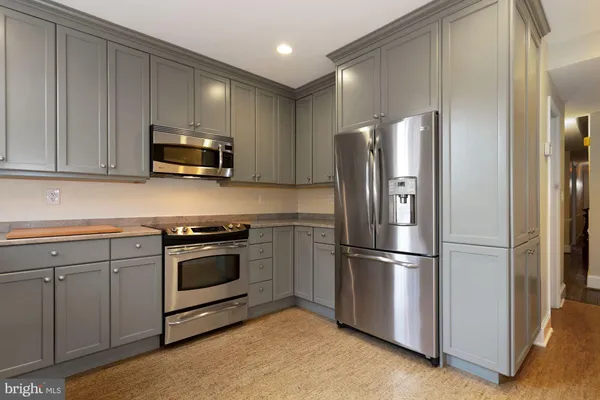 a kitchen with appliances a sink and cabinets