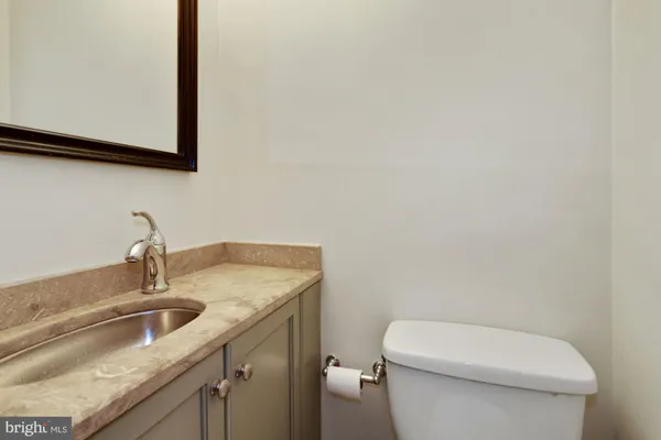 a bathroom with a granite countertop toilet sink and mirror