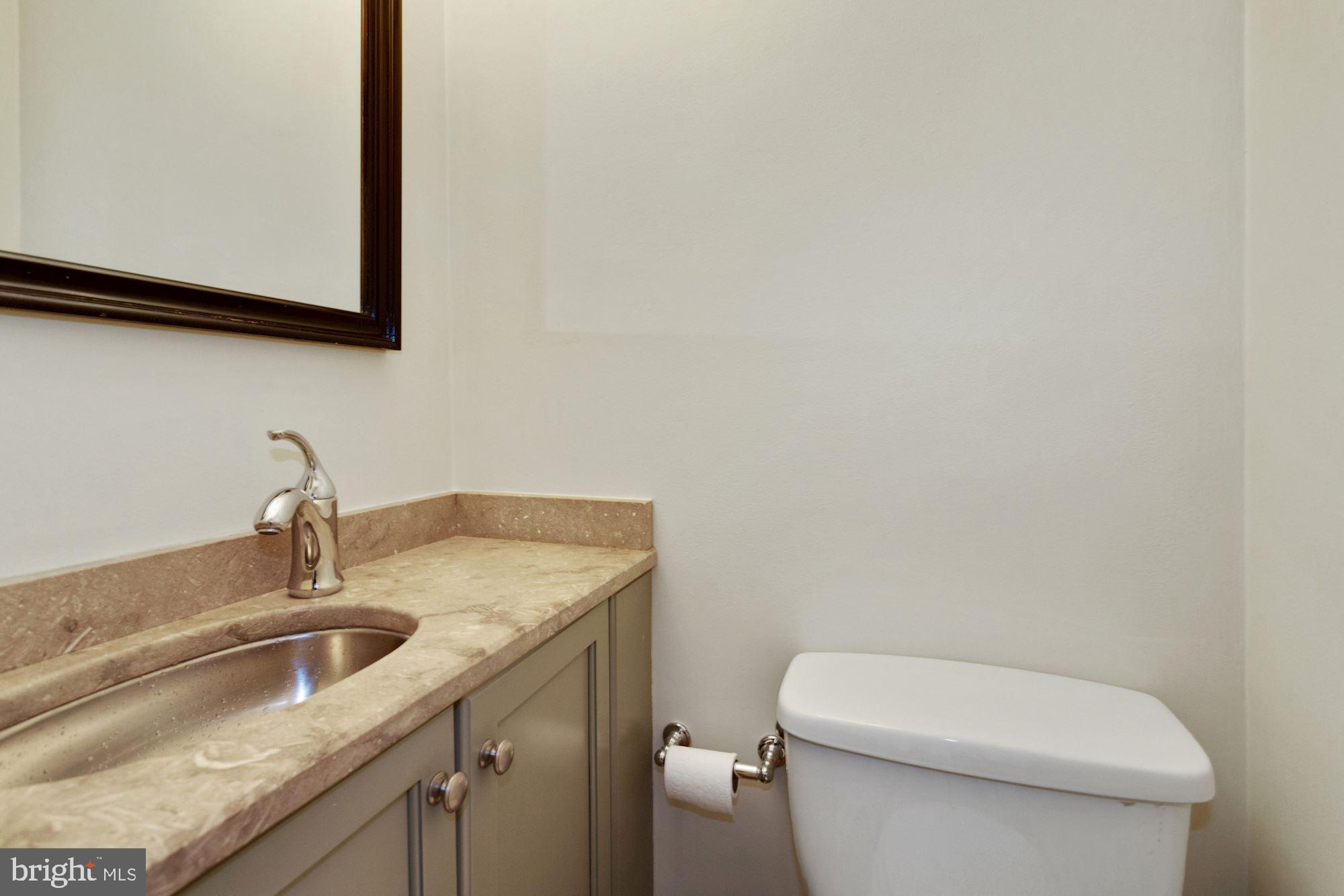 315 Constitution Avenue Northeast Washington, DC 20002 - Photo 17 of 32 a bathroom with a granite countertop toilet sink and mirror