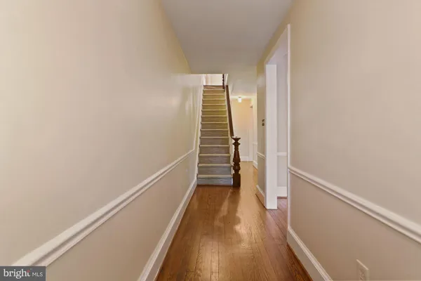 a view of a hallway with wooden floor and stairs