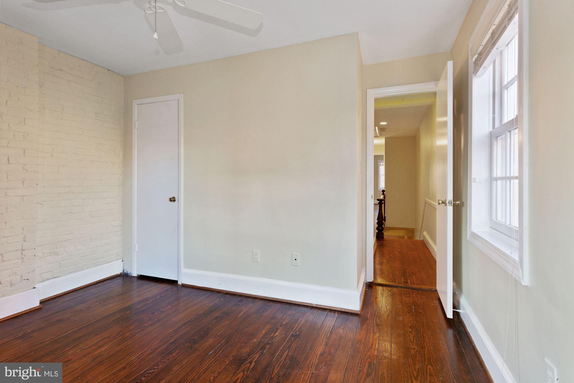 315 Constitution Avenue Northeast Washington, DC 20002 - Photo 27 of 32 an empty room with wooden floor and a window