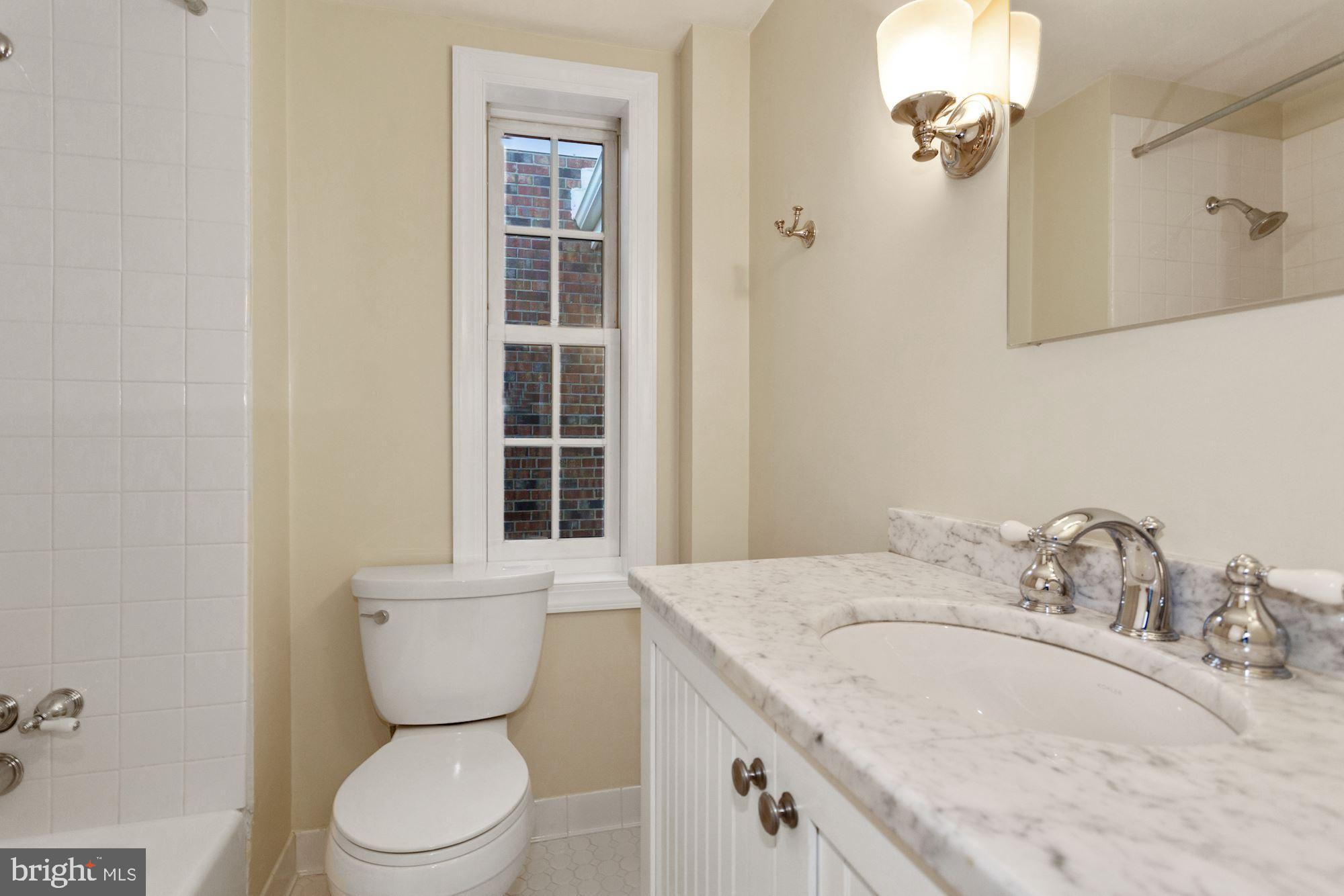 315 Constitution Avenue Northeast Washington, DC 20002 - Photo 28 of 32 a bathroom with a granite countertop sink toilet and shower