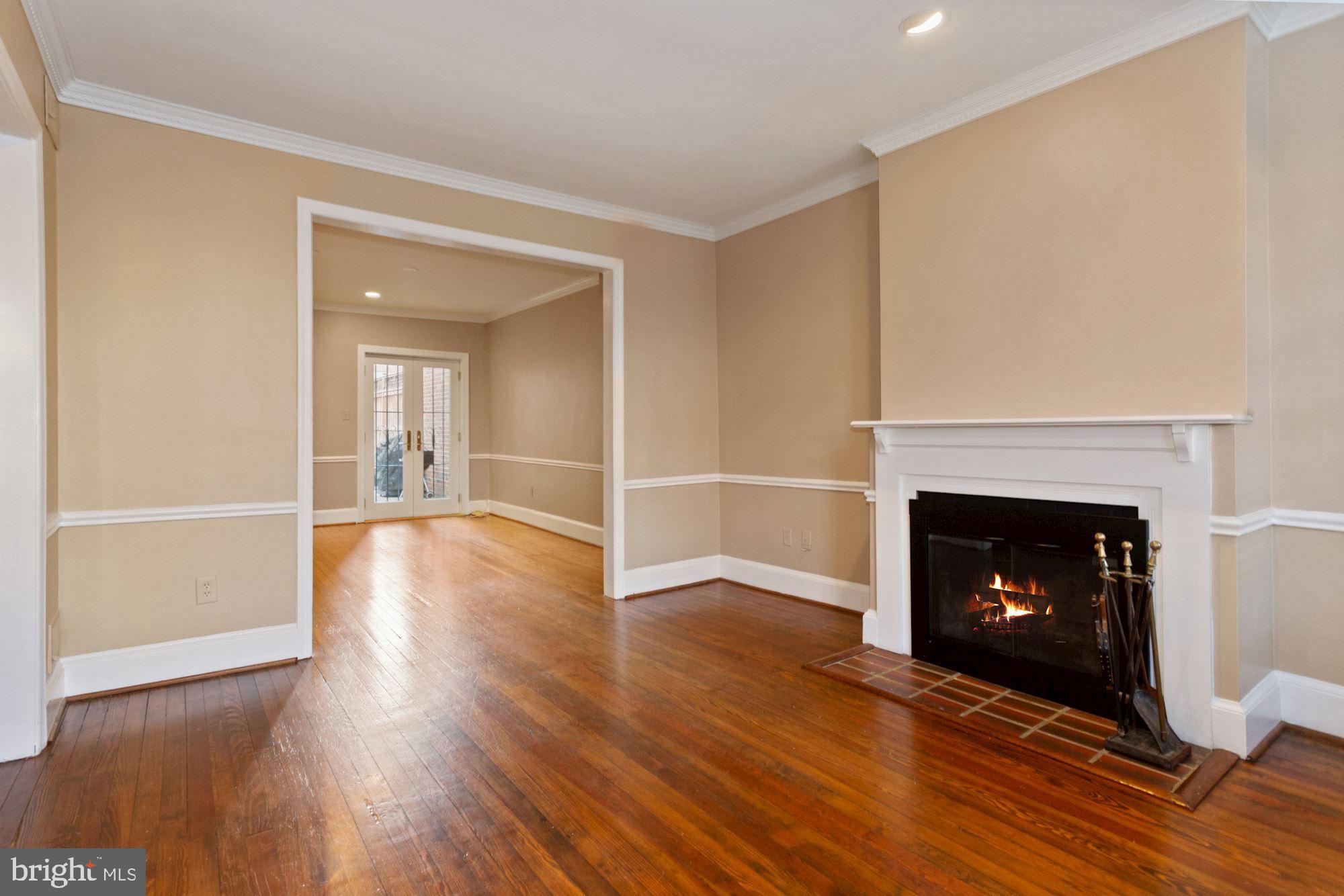 315 Constitution Avenue Northeast Washington, DC 20002 - Photo 6 of 32 a view of an empty room with wooden floor fireplace and a window