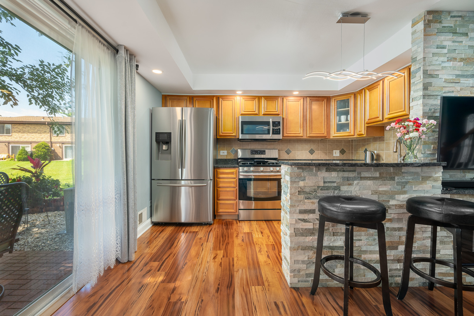 12 Cour Monnet Palos Hills, IL 60465 - Photo 2 of 27 a kitchen with stainless steel appliances granite countertop a stove top oven a sink and a refrigerator