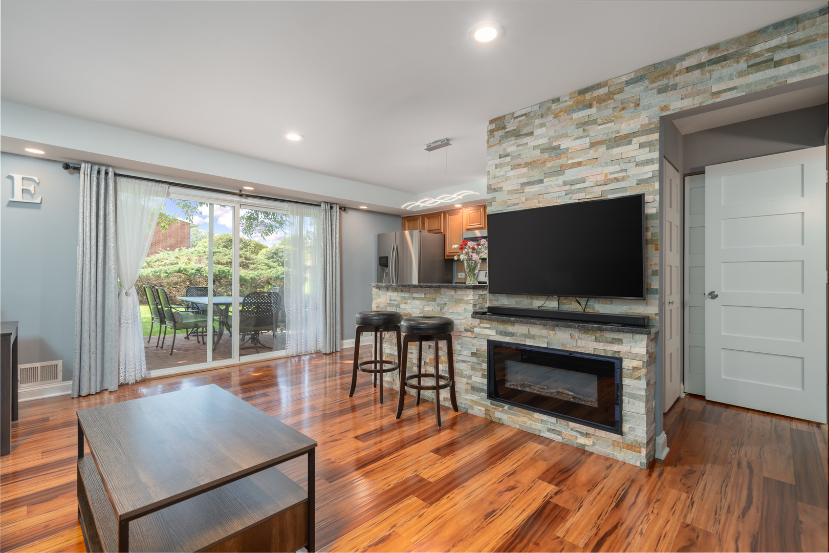 12 Cour Monnet Palos Hills, IL 60465 - Photo 3 of 27 a living room with furniture a flat screen tv and a fireplace