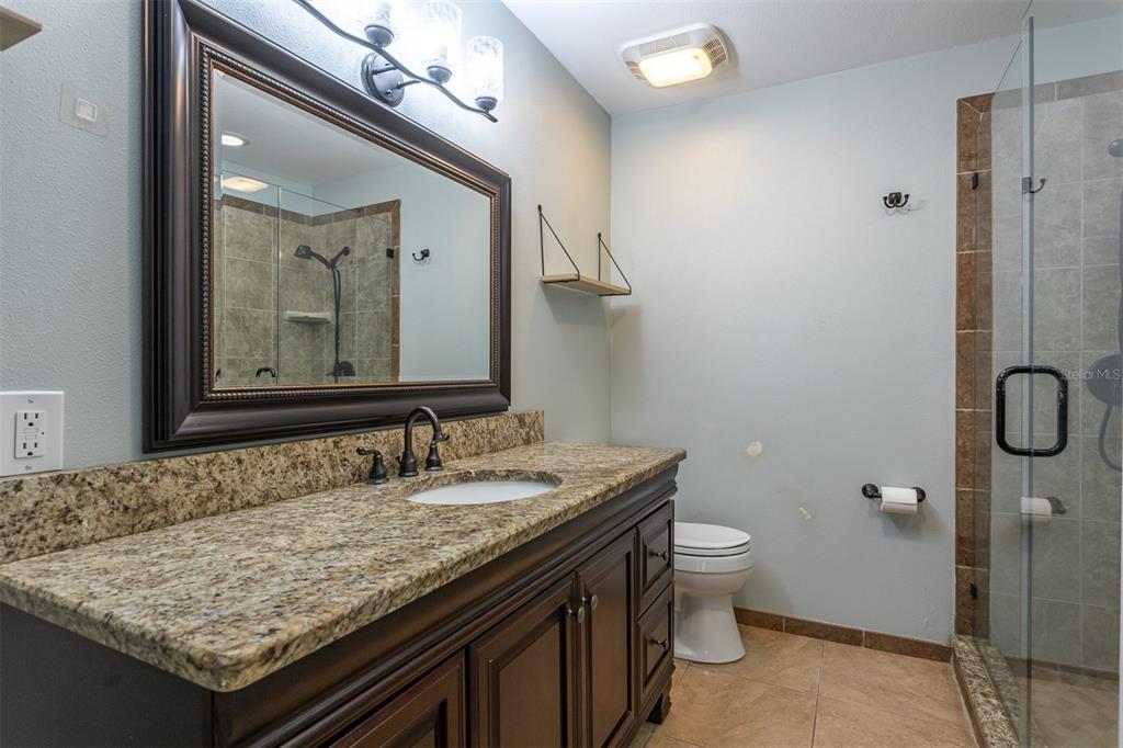 19029 US Highway 19 North, Unit 10C Clearwater, FL 33764 - Photo 15 of 61 a bathroom with a granite countertop sink and a mirror
