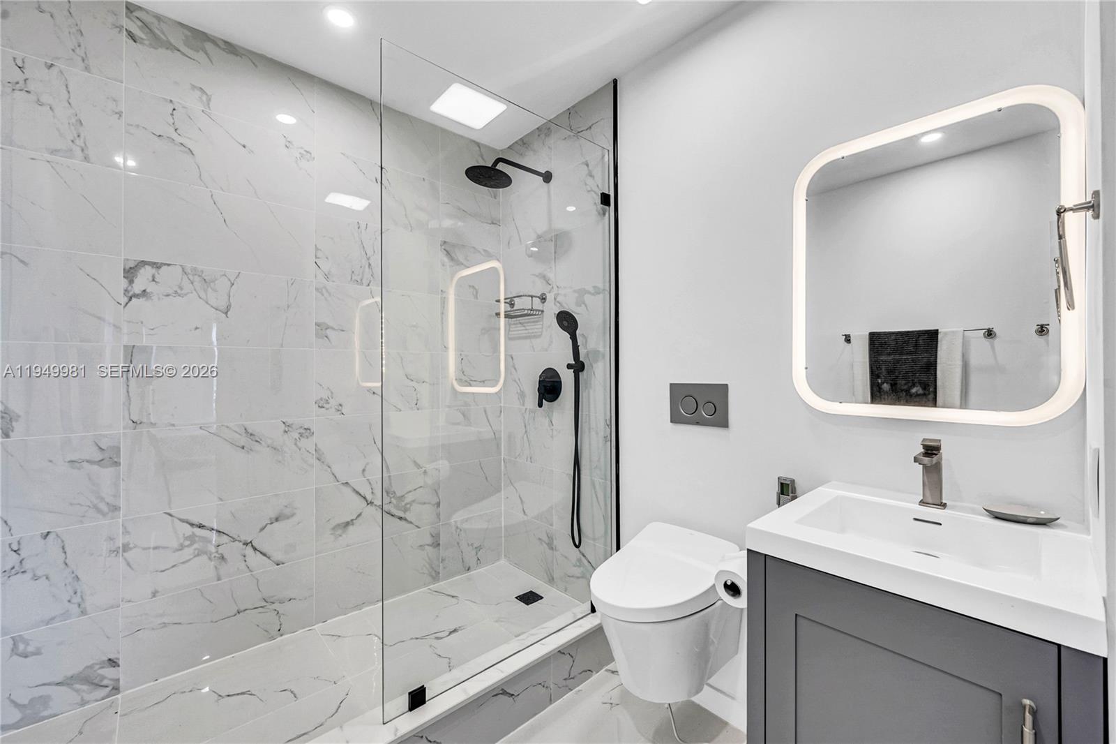 1500 Bay Road, Unit 1536S Miami Beach, FL 33139 - Photo 12 of 34 a bathroom with a toilet sink shower and mirror