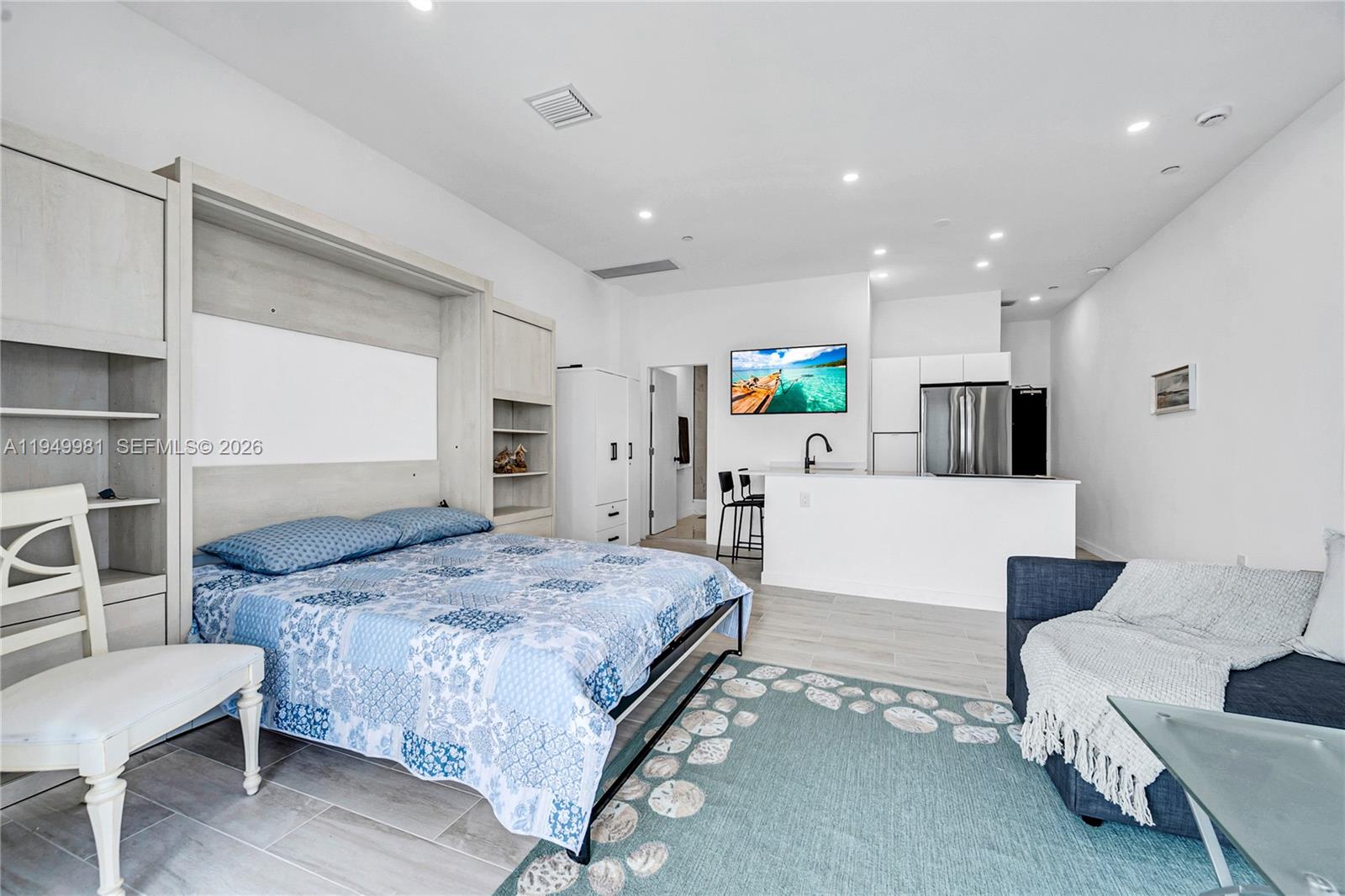 1500 Bay Road, Unit 1536S Miami Beach, FL 33139 - Photo 15 of 34 a bedroom with a bed a table and chair