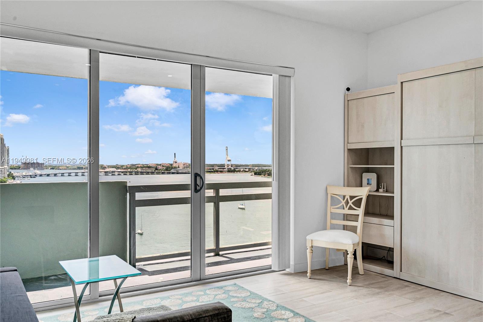1500 Bay Road, Unit 1536S Miami Beach, FL 33139 - Photo 25 of 34 a living room with a large window and a table chair