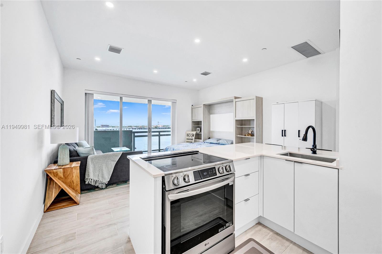 1500 Bay Road, Unit 1536S Miami Beach, FL 33139 - Photo 8 of 34 a kitchen with stainless steel appliances granite countertop a stove a sink and a refrigerator