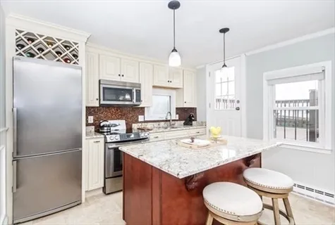 a kitchen with a refrigerator a sink dishwasher a stove and a dining table with wooden floor