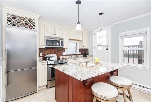 a kitchen with a refrigerator a sink dishwasher a stove and a dining table with wooden floor