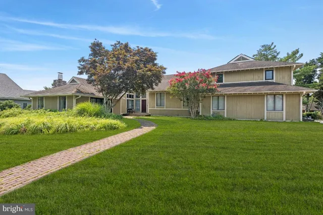 a front view of a house with a garden and yard
