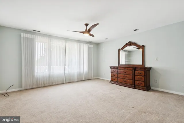 an empty room with windows and cabinet