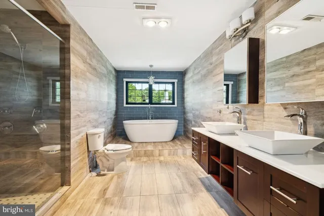 a spacious bathroom with a double vanity sink a mirror and a shower
