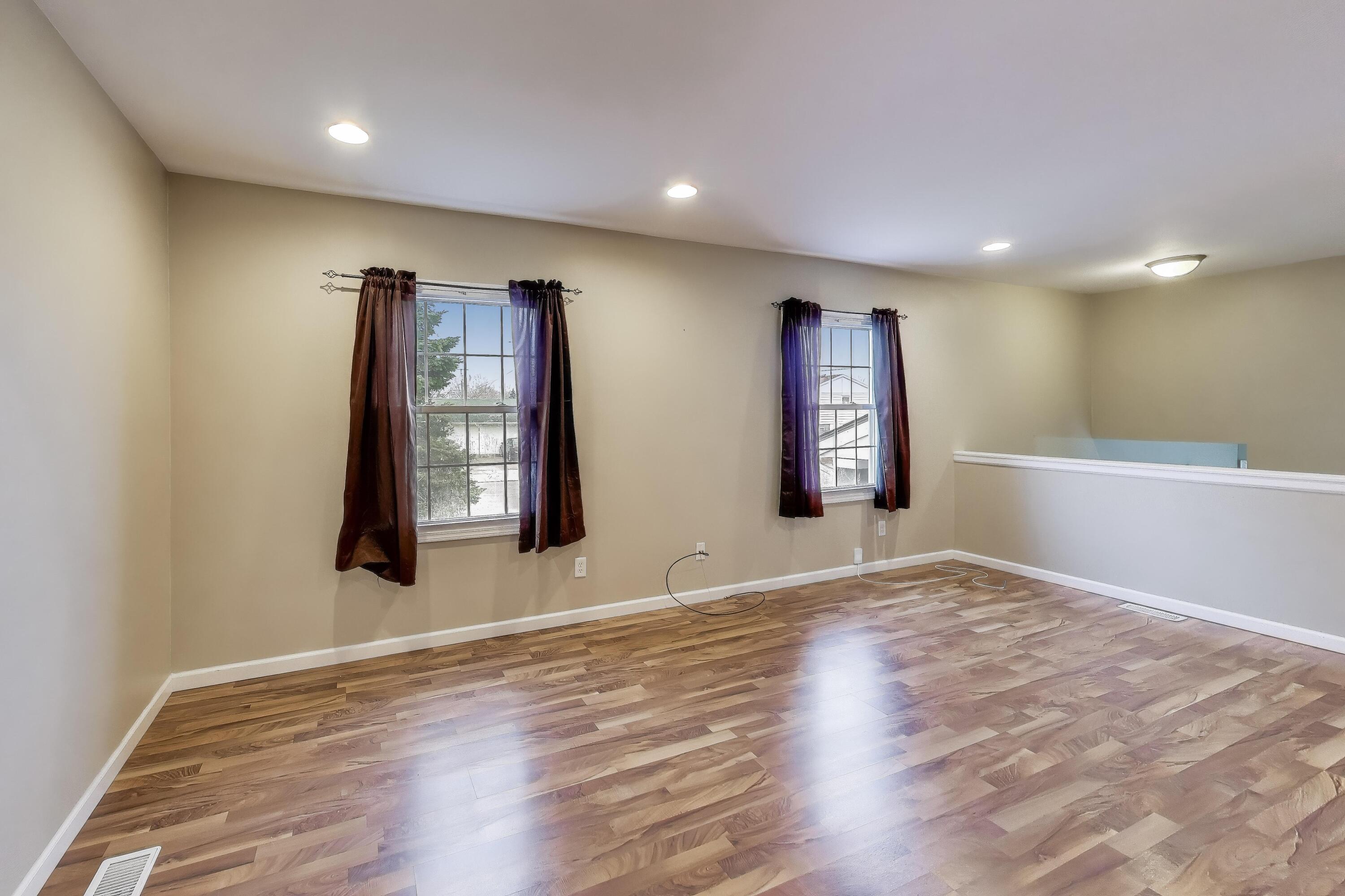 816 East 39th Lane Griffith, IN 46319 - Photo 6 of 42 a view of an empty room with window and wooden floor