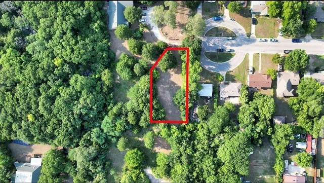 an aerial view of residential house with outdoor space and trees all around
