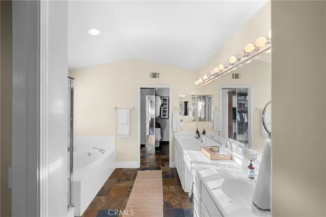 a large bathroom with a glass shower door and a bathtub