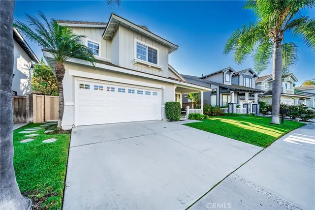 a view of a white house with a big yard and potted plants