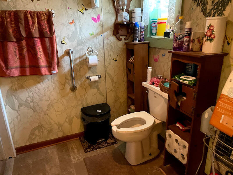 5161 Griffith Mill Road Holt, FL 32564 - Photo 15 of 25 a bathroom with a toilet and a shower curtain